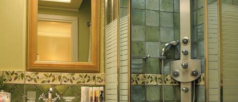 A bathroom with a glass-enclosed shower, a wooden vanity, and a large mirror.
