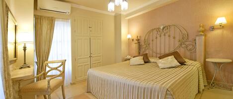 A bedroom with a bed, a chair, a desk, and a lamp.