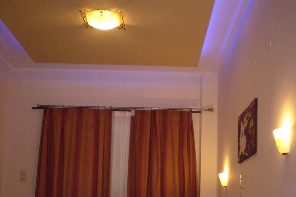A hotel room with a large bed, a nightstand, and a painting on the wall.