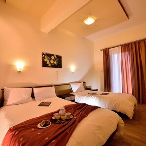 Habitación de hotel con dos camas, un cuadro en la pared y una bandeja de desayuno sobre la cama.
