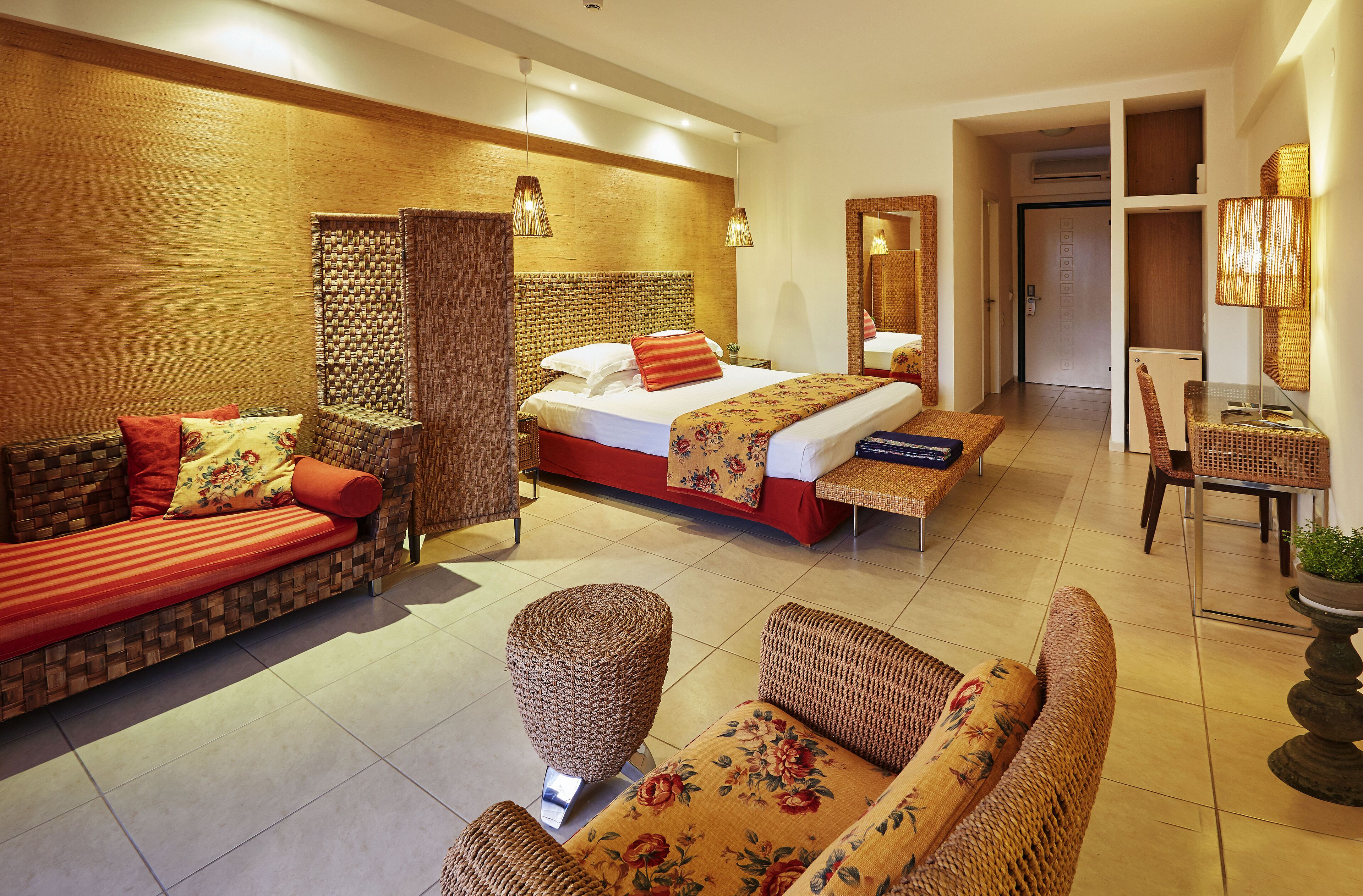 Una habitación de hotel con cama, sofá, sillón y una mesita.