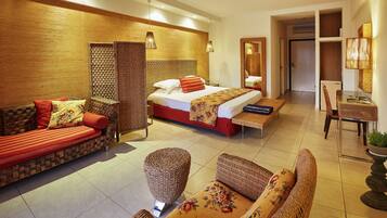 Una habitación de hotel con cama, sofá, sillón y una mesita.