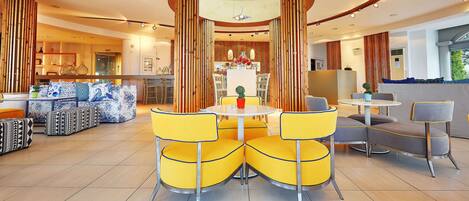 Un comedor moderno con una mesa redonda central, sillas amarillas y disposición para sentarse.