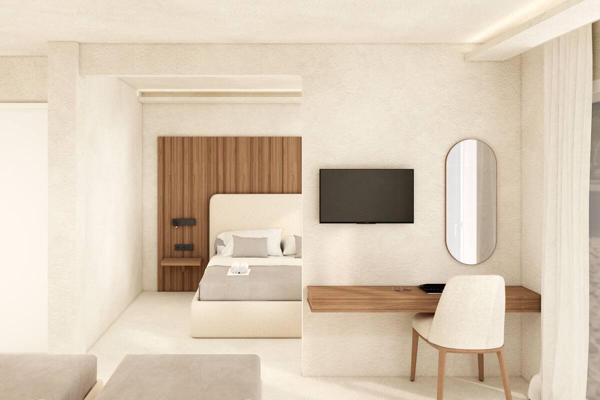 Une chambre d’hôtel moderne équipée d’un lit, d’un bureau, d’une chaise, d’une télévision et d’un grand miroir.