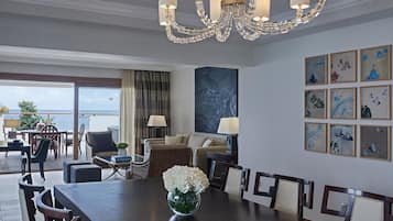 A spacious dining area with a wooden table and chairs, a chandelier, and a large painting on the wall.