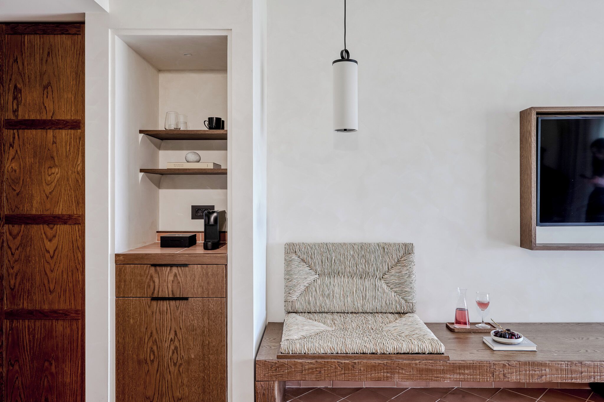 En moderne stue med et træskab, reoler, en sofa, en pendel og et fjernsyn.