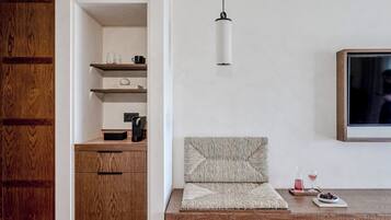En moderne stue med et træskab, reoler, en sofa, en pendel og et fjernsyn.
