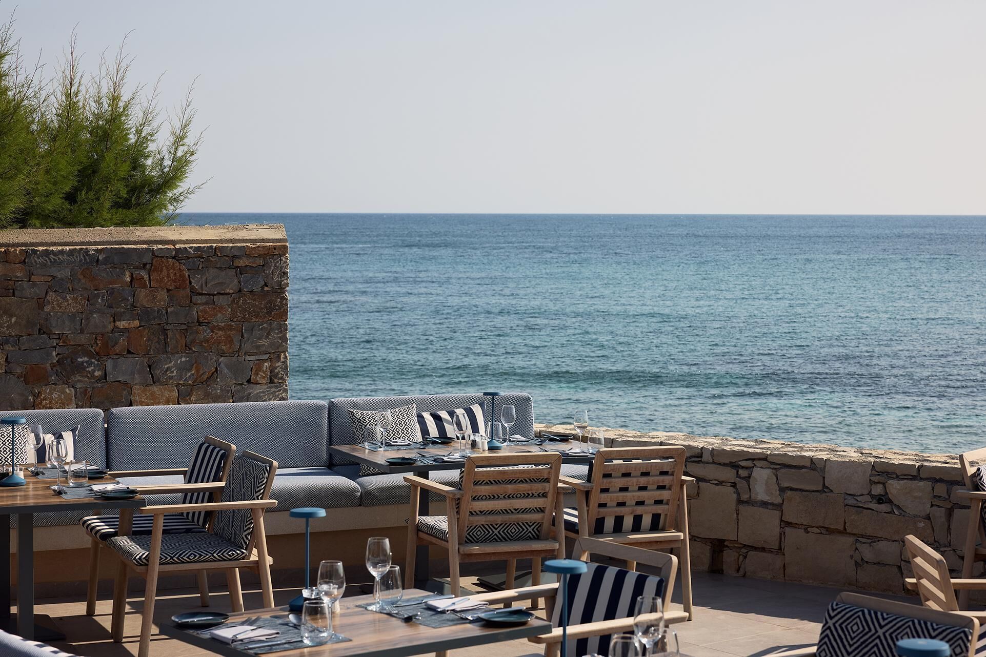 Un espace extérieur aménagé avec des murs en pierre et une vue sur la mer.