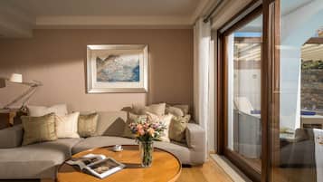 A modern living room with a sofa, a coffee table with a magazine, a vase with flowers, and a framed picture on the wall.