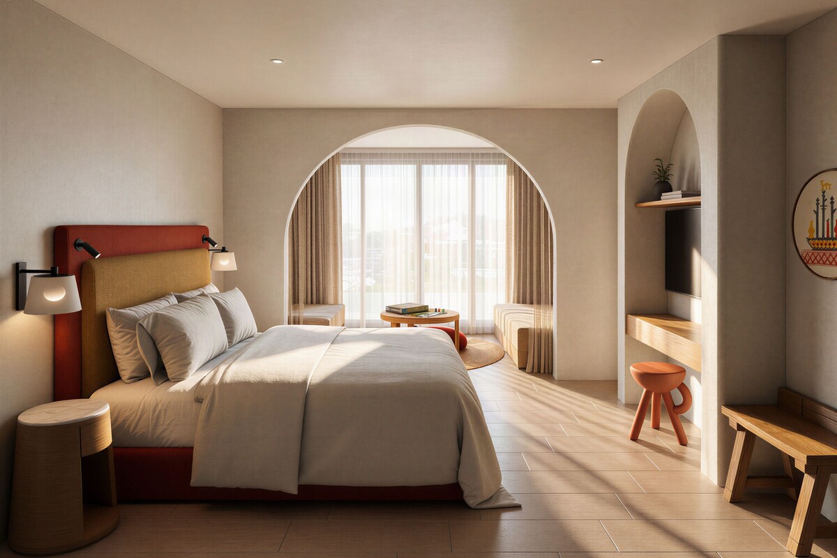 Quarto de hotel moderno com uma cama grande, uma escrivaninha, uma cadeira, uma mesinha e uma televisão.