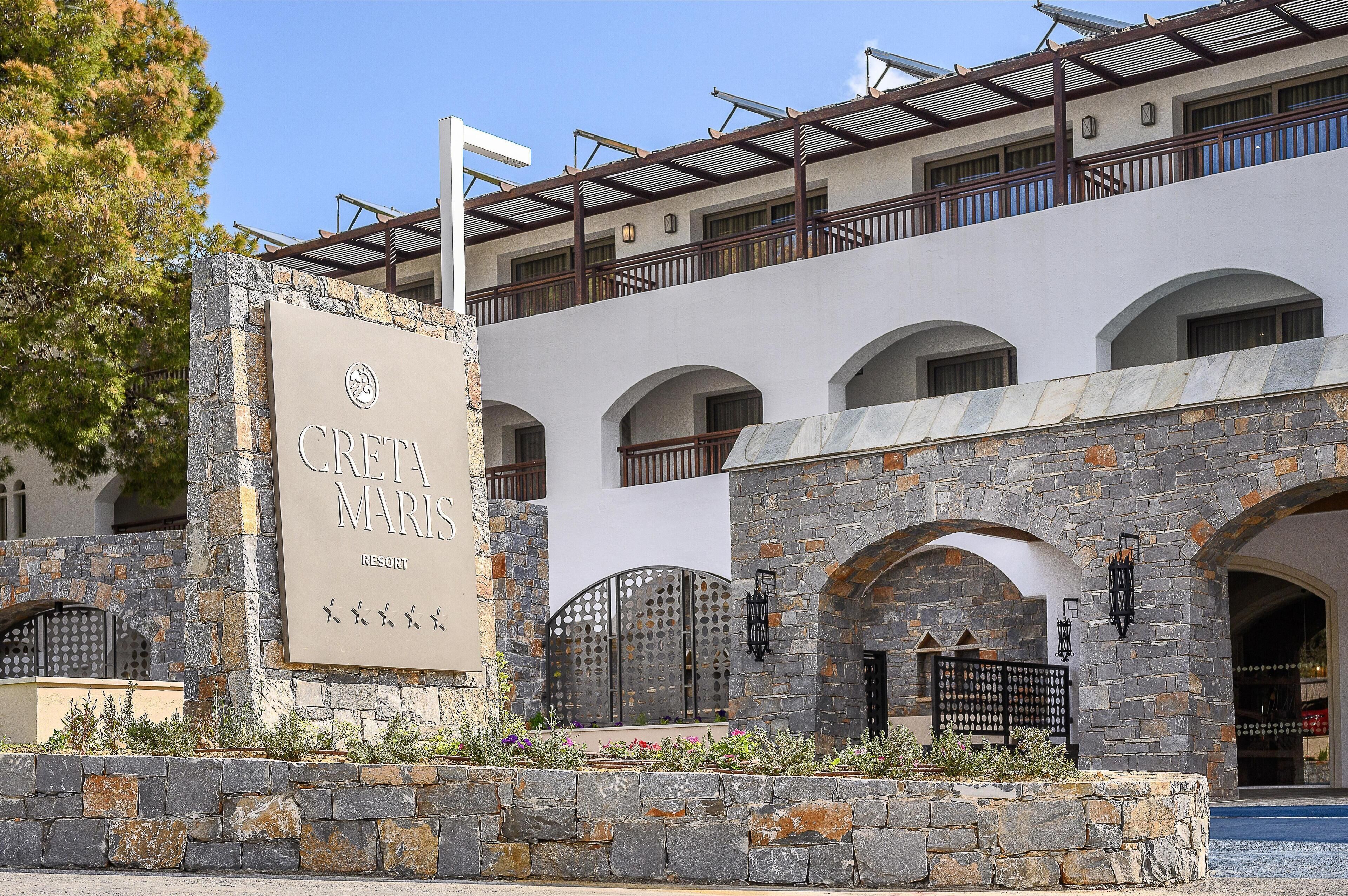 Ein Gebäude mit einem Schild, auf dem „CRETA MARIS RESORT“ steht, und steinernen Bögen.