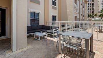 A courtyard with outdoor seating, including a sofa and a table with chairs.