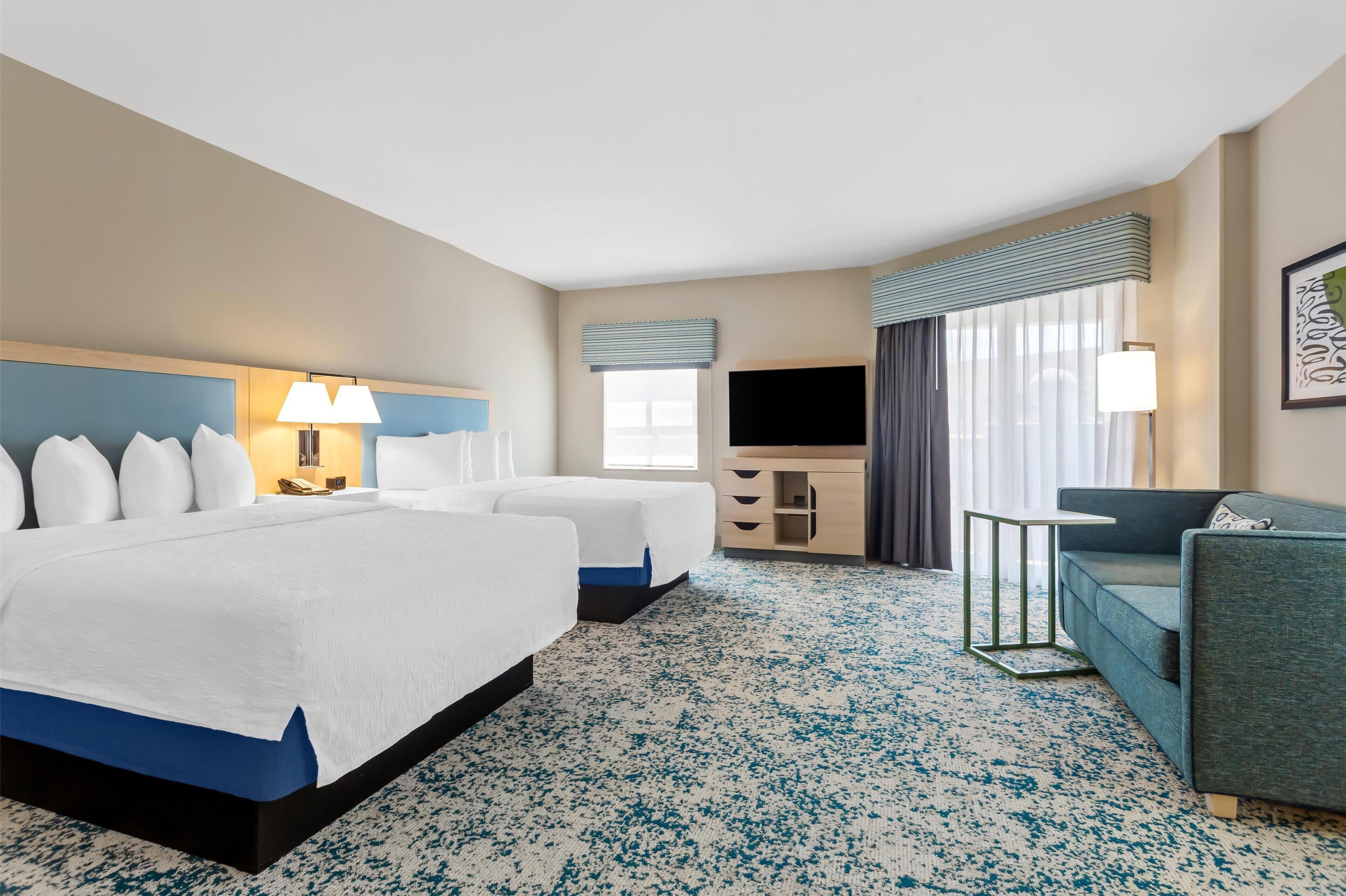 studio suite, 2 queen beds, sofabed with balcony | living area | 0-inch tv with satellite channels, netflix, hulu