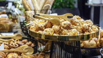Un bufé con diversos productos de panadería, incluyendo pasteles y pan.