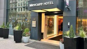 The exterior of the Mercure Hotel with a modern facade, large windows, and potted plants at the entrance. - Mercure Hotel Kaiserhof Frankfurt City Center (Frankfurt)