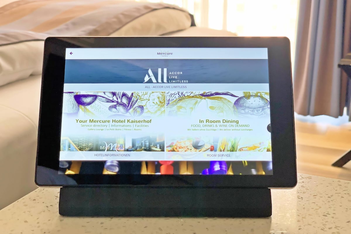 Ein Tablet zeigt Hotelinformationen mit Bereichen für Dienstleistungen, Zimmerservice und Annehmlichkeiten.