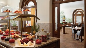 A buffet setup with various food items and a dining area with tables and chairs.