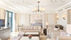 Une chambre d’hôtel spacieuse, dotée d’un grand lit, d’un canapé, d’une télévision et d’un coin repas.