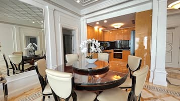 A dining area with a round table, chairs, and a vase of white flowers.