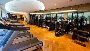 Une salle de sport équipée de tapis de course, d’appareils de musculation et d’autres équipements d’exercice.