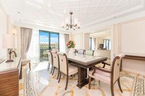 Un comedor amplio con una mesa grande, sillas y una araña.
