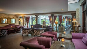 Un amplio salón con asientos cómodos, ventanas grandes e iluminación decorativa.