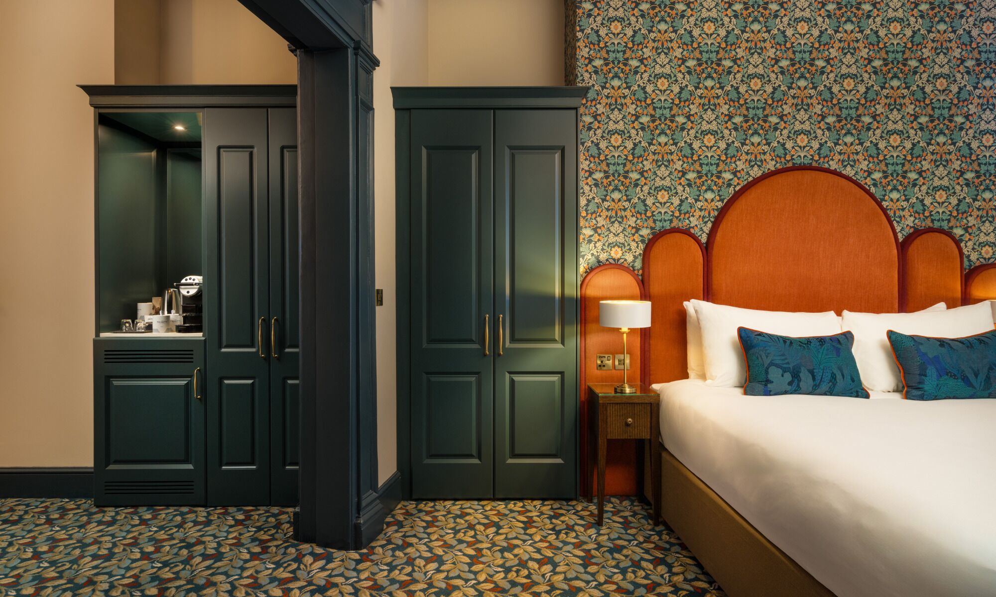 Una habitación de hotel con cama, mesita de noche, armario y zona de baño.