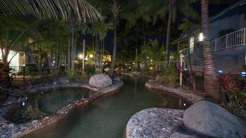 Stroll through our serene courtyard, surrounded by lush tropical plants and palm trees, featuring a tranquil water feature and a peaceful ambiance.