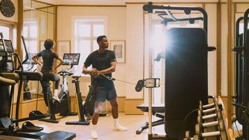 A gym with exercise equipment, a large mirror, and a window.