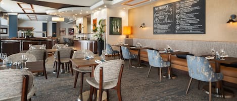 A restaurant with a bar area, seating arrangements, and a menu board on the wall.