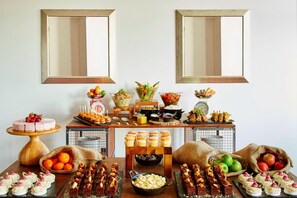A buffet table with various food items and desserts. - Delta Hotels Bexleyheath (Bexleyheath)
