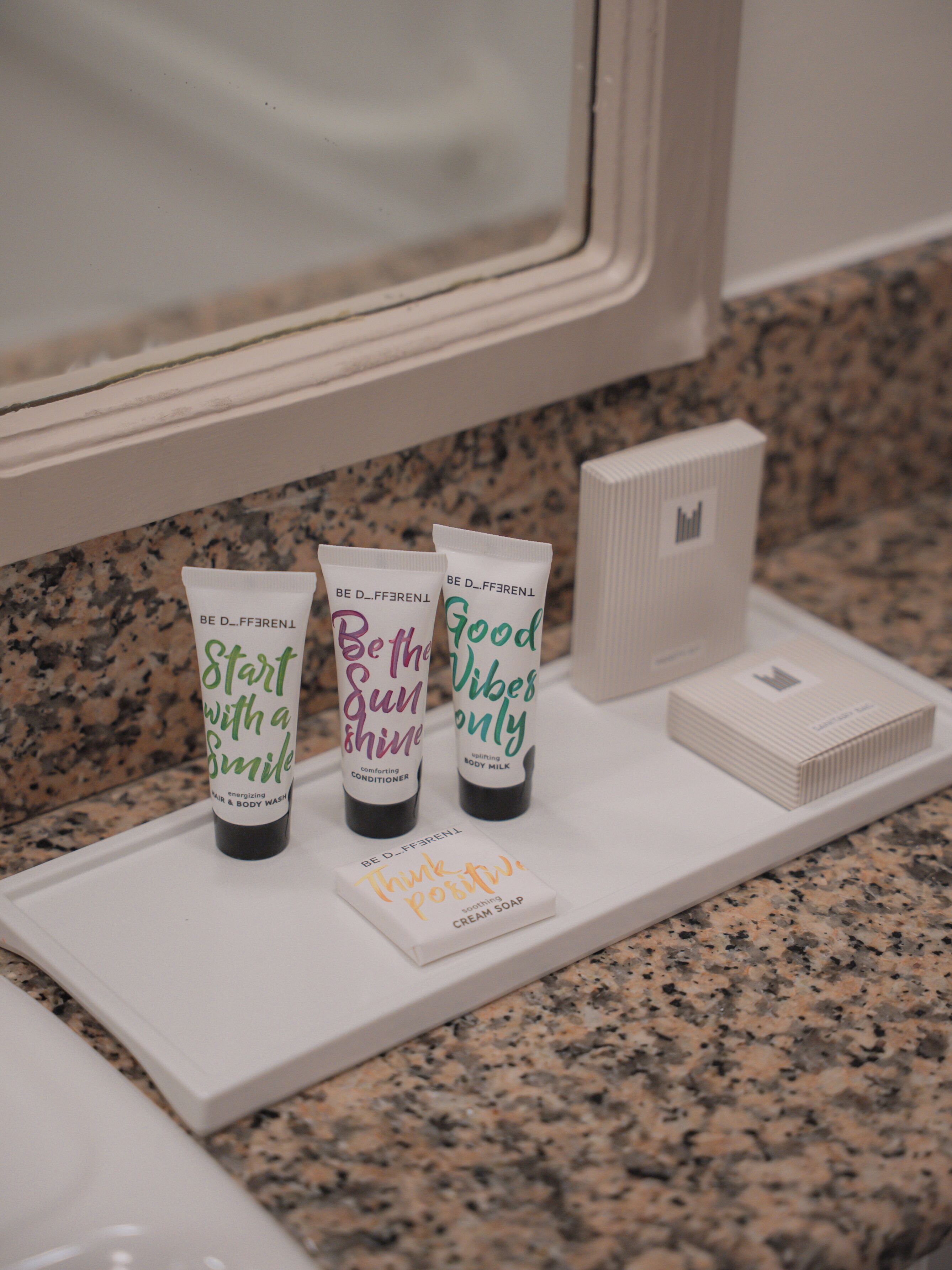 A countertop with three tubes of body wash and a bar of soap.