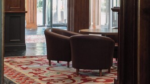 A lobby with a patterned carpet, wooden furniture, and large windows. - Copthorne Hotel Cardiff-Caerdydd (Cardiff)
