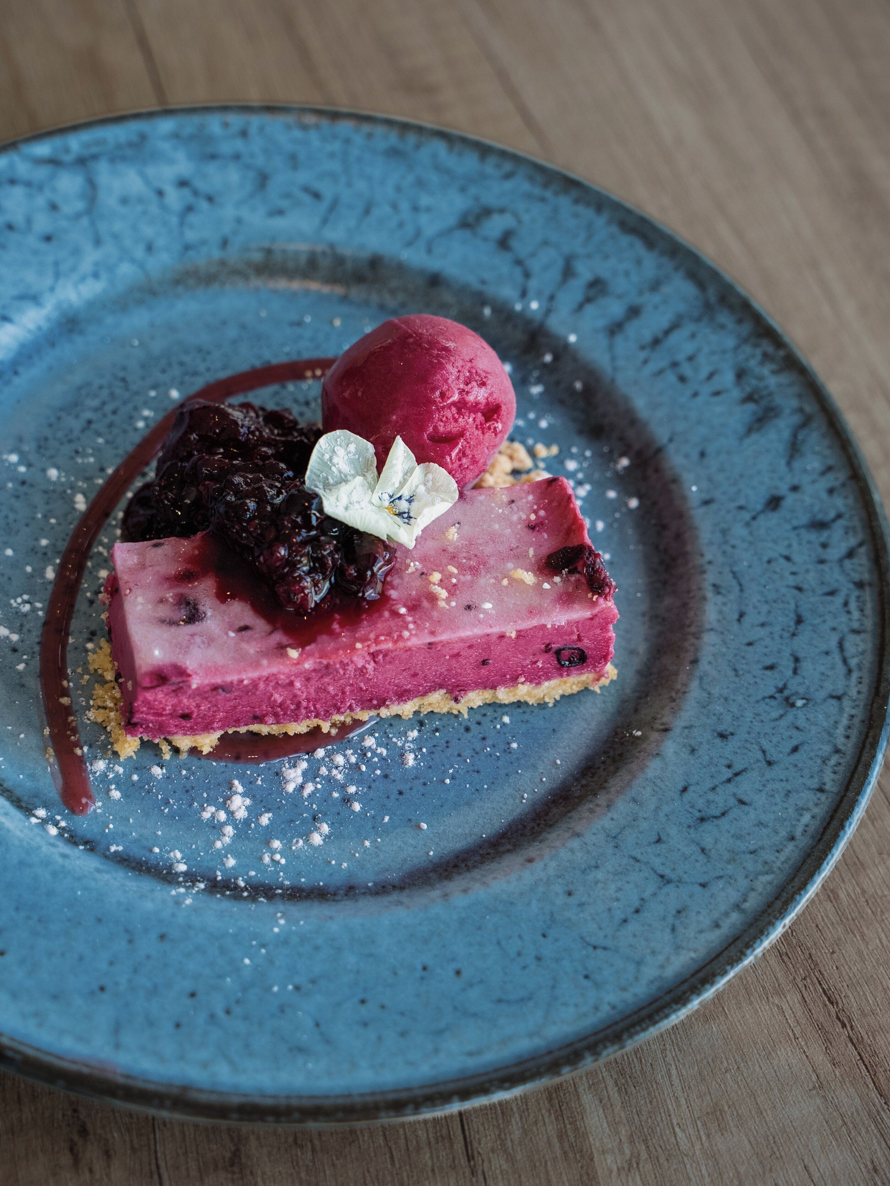 Un postre sobre un plato azul con un fondo de mesa de madera.