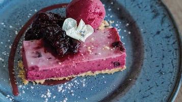 Un postre sobre un plato azul con un fondo de mesa de madera.