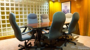 A conference room with a glass partition, a wooden panel wall, and a framed cityscape picture. - The Pearl Manila Hotel (Manila)
