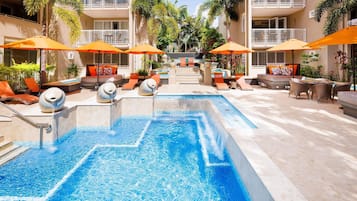 Een buitenzwembad, parasols bij het zwembad en ligstoelen