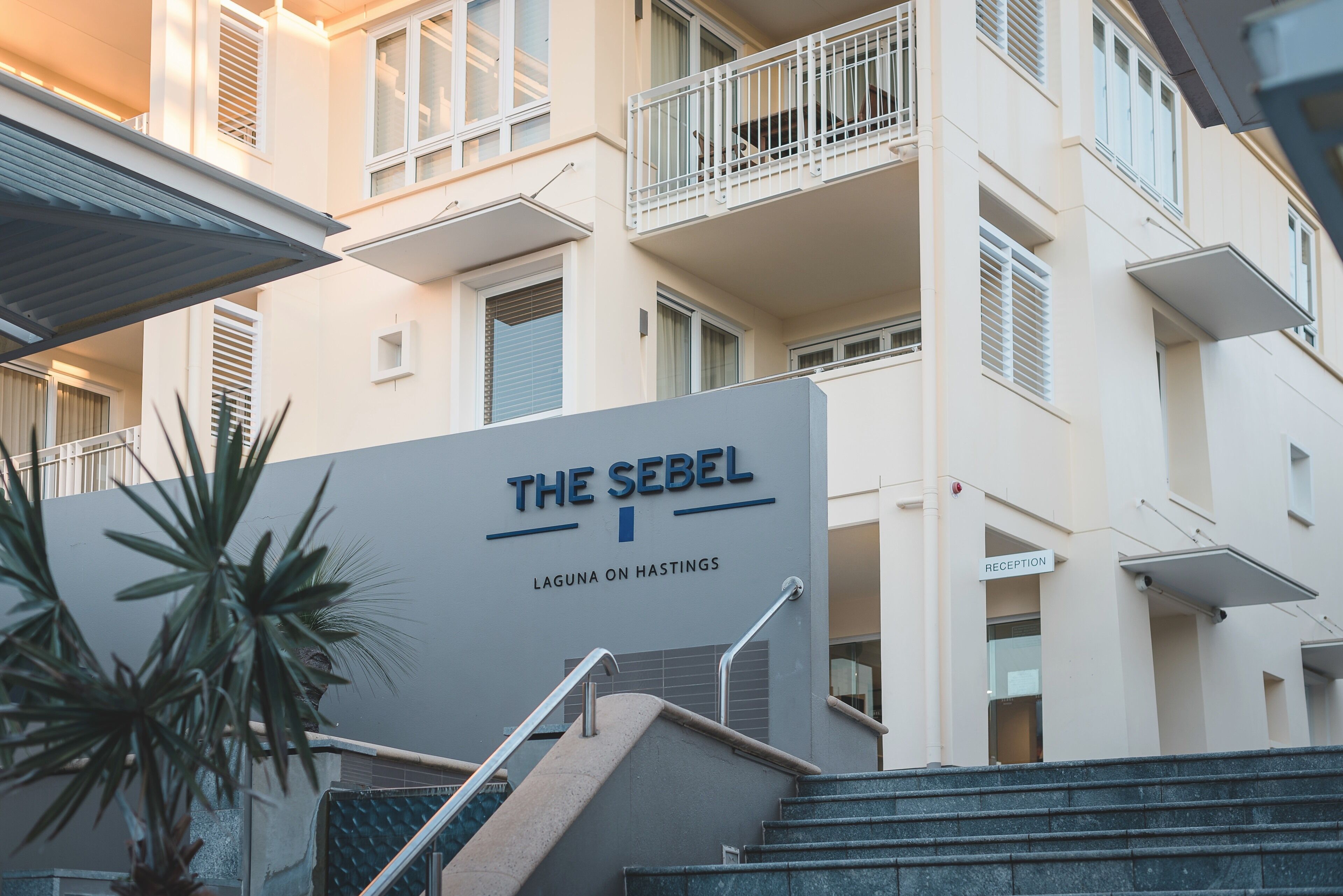 Ein Hotel Eingang mit einem Schild, auf dem 'The Sebel Laguna on Hastings' steht.