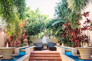 Una piscina al aire libre, sombrillas, sillones reclinables de piscina