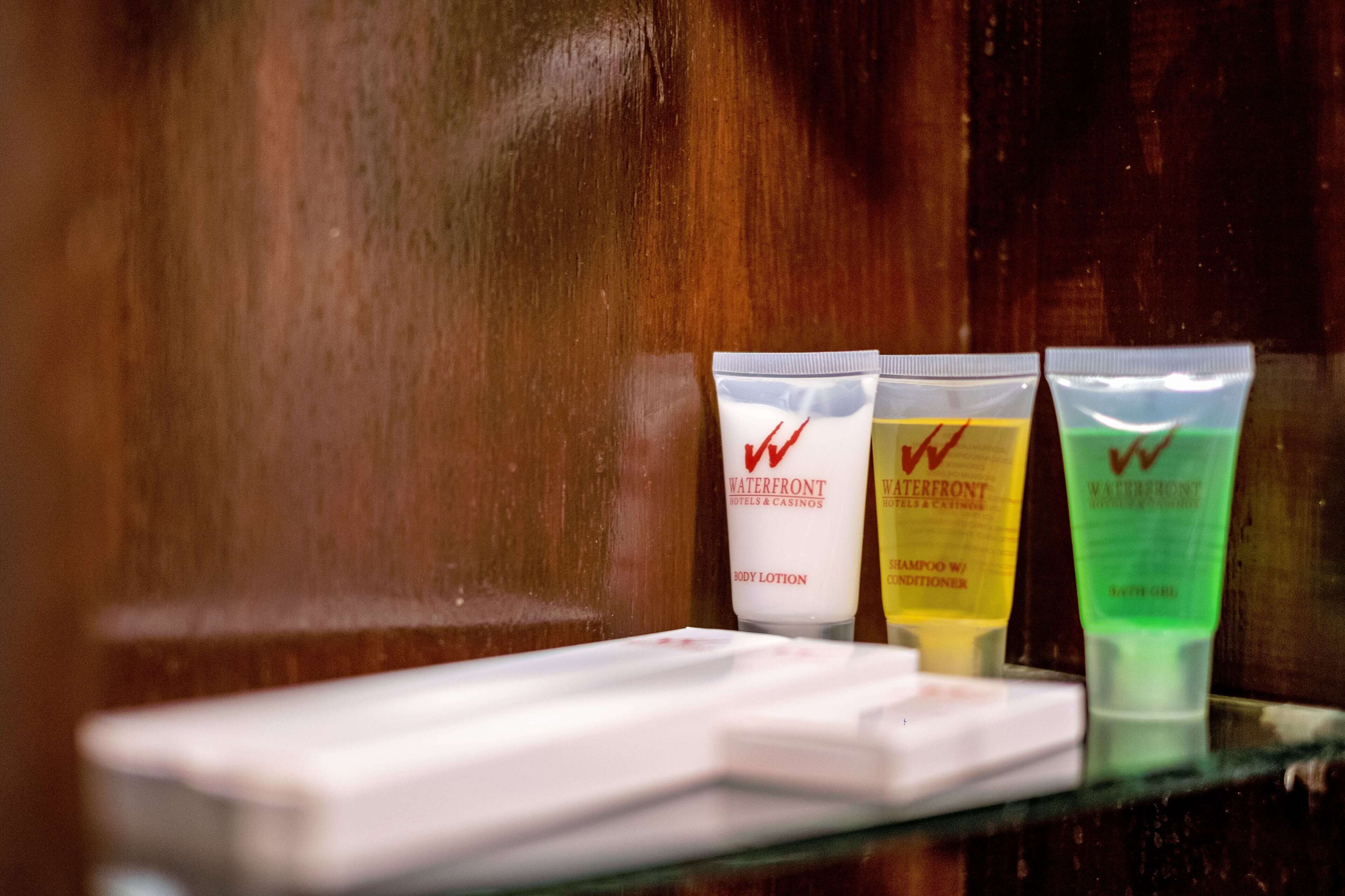 Three toiletry tubes on a wooden surface.