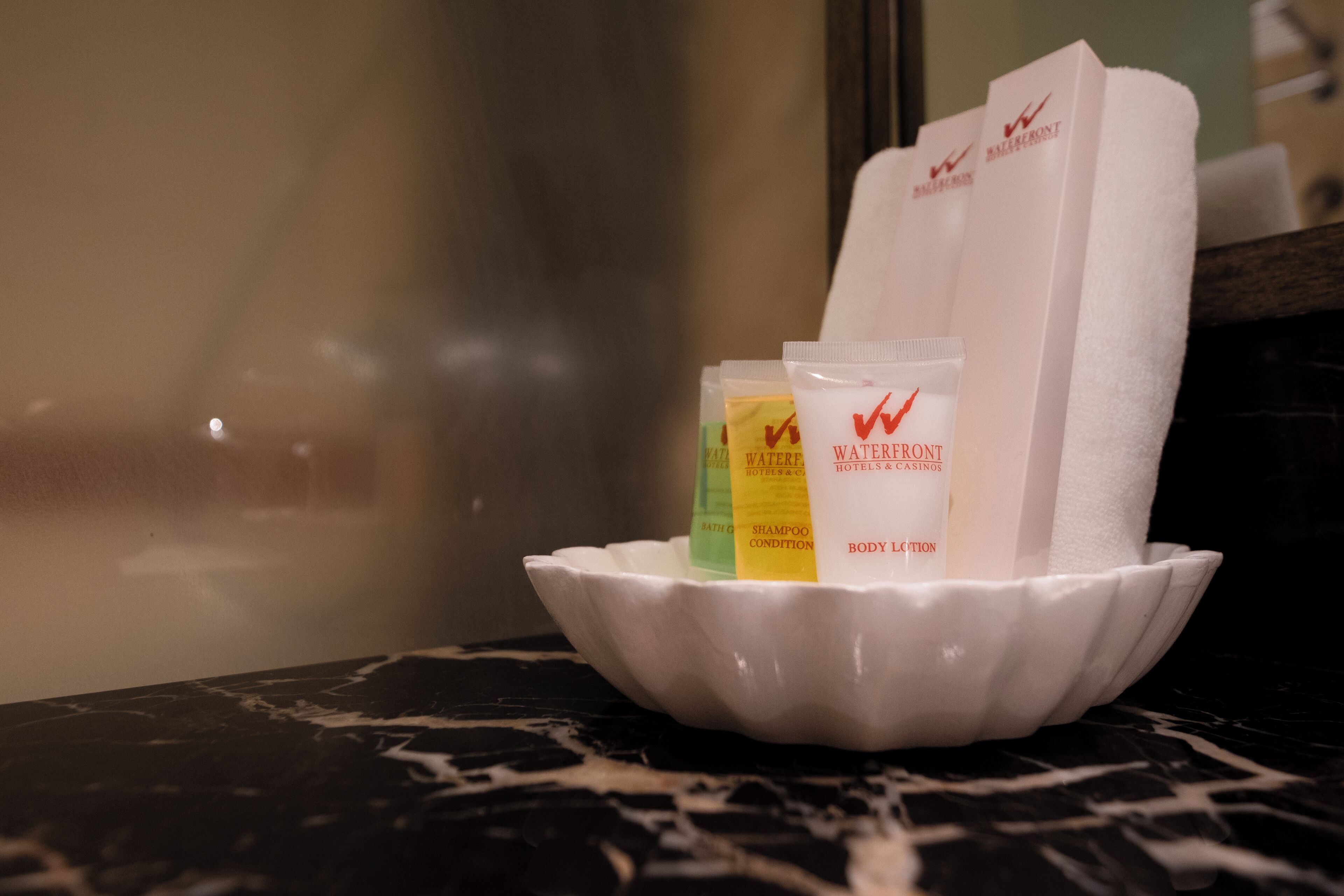 A white tray with toiletries on a marble countertop.