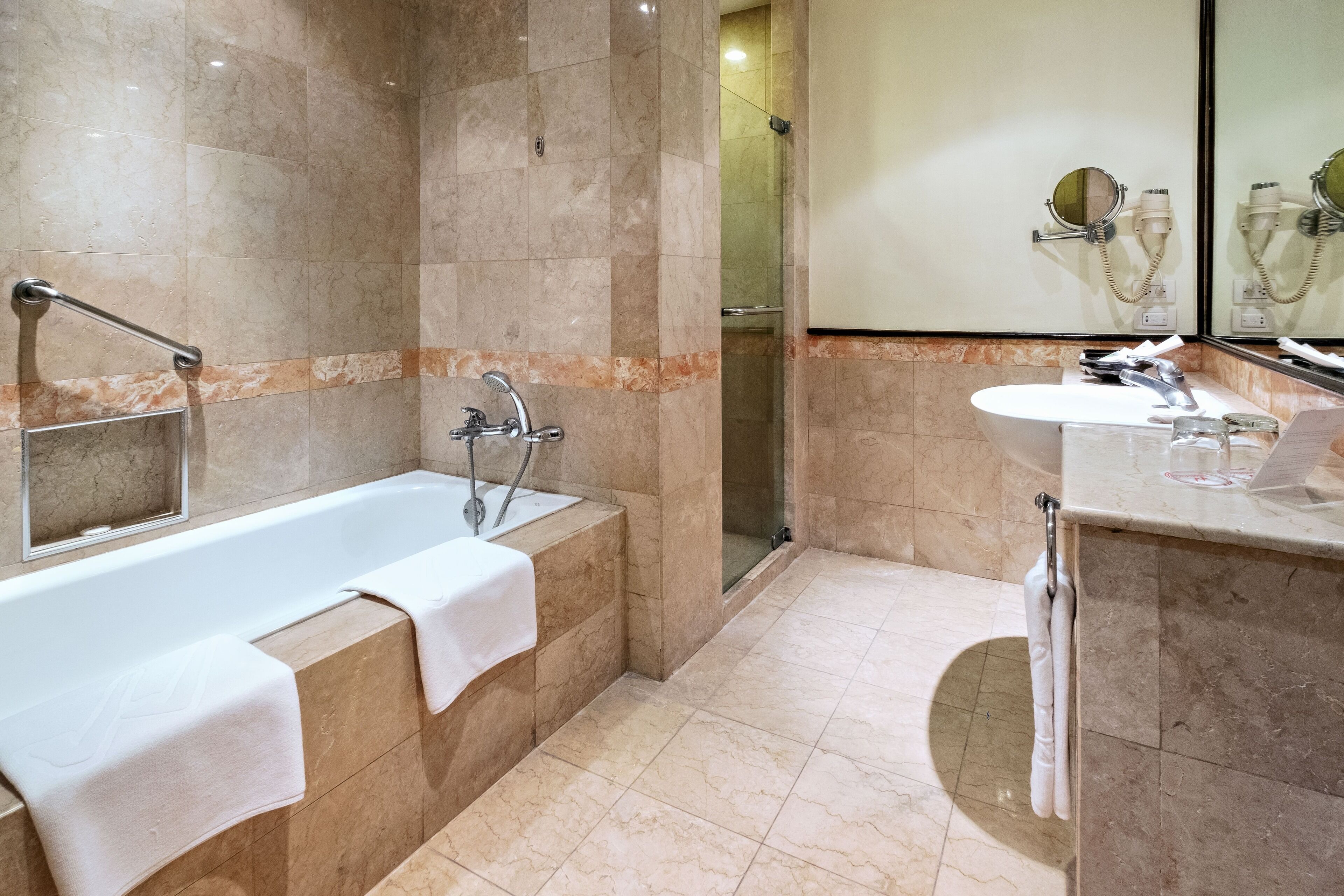 A modern bathroom with a bathtub, a shower, and a sink.