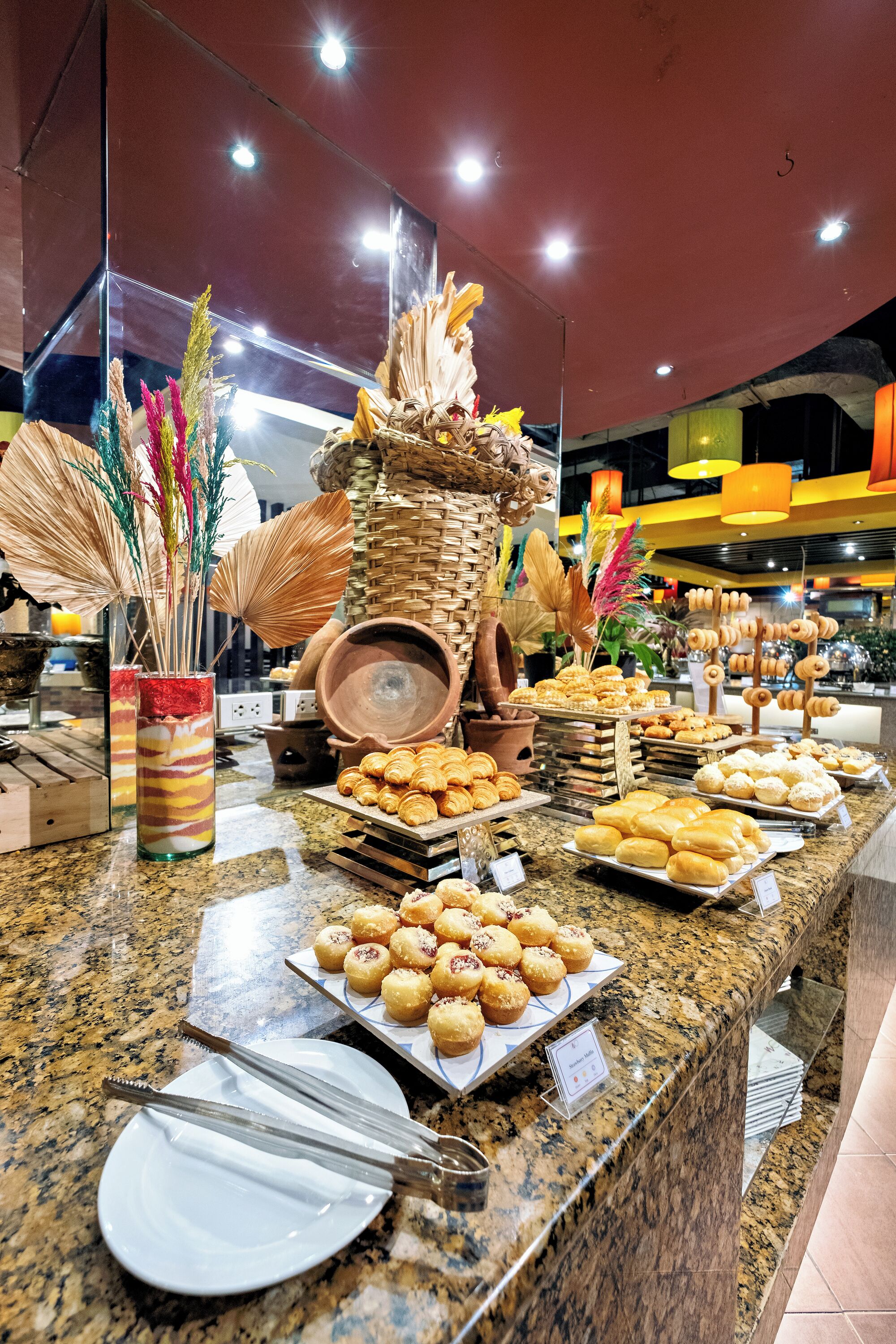 Un buffet proposant une variété de pâtisseries et agrémenté d'un centre de table décoratif.