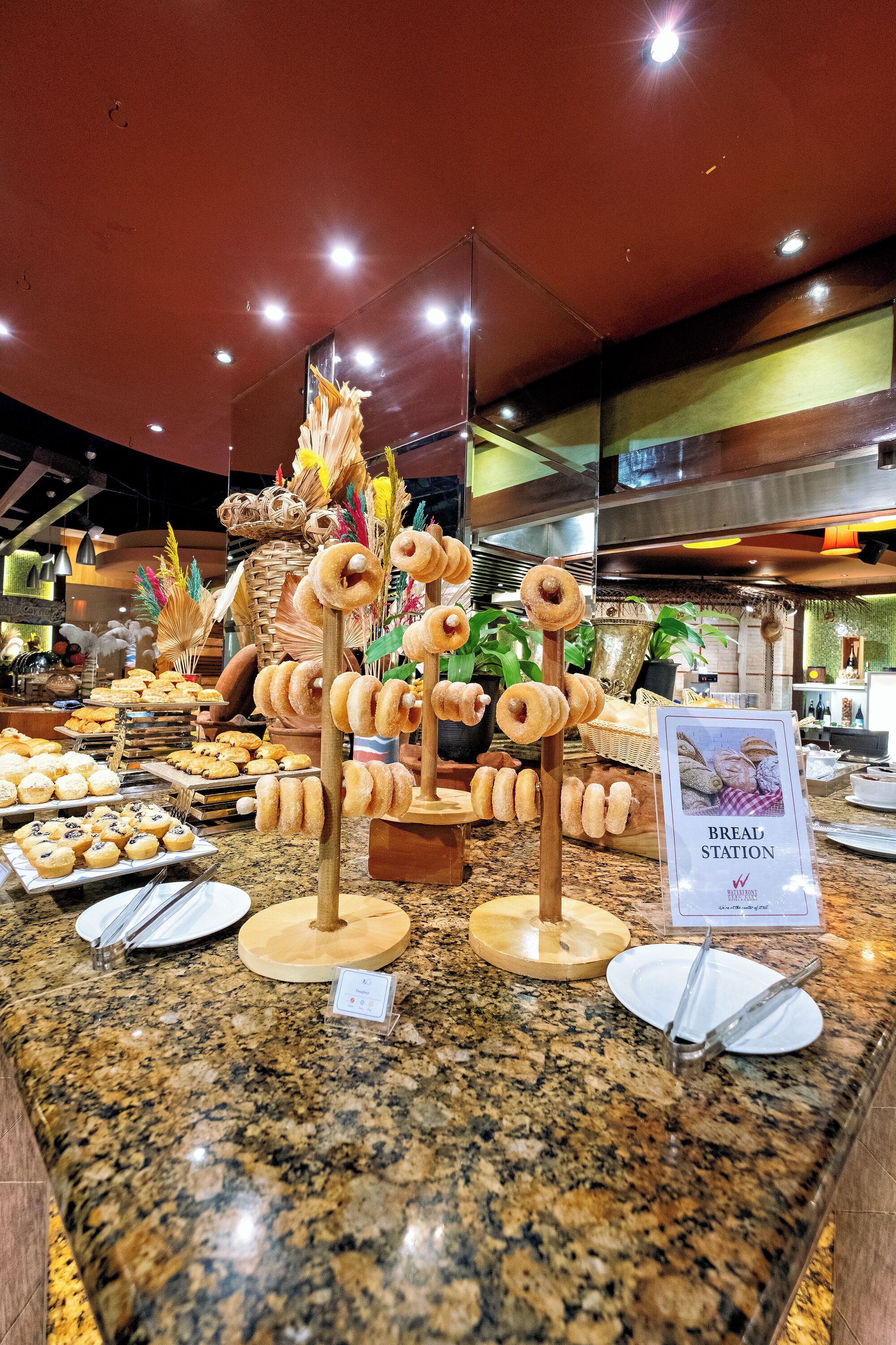 A buffet area with various food items and a sign indicating a bread station.