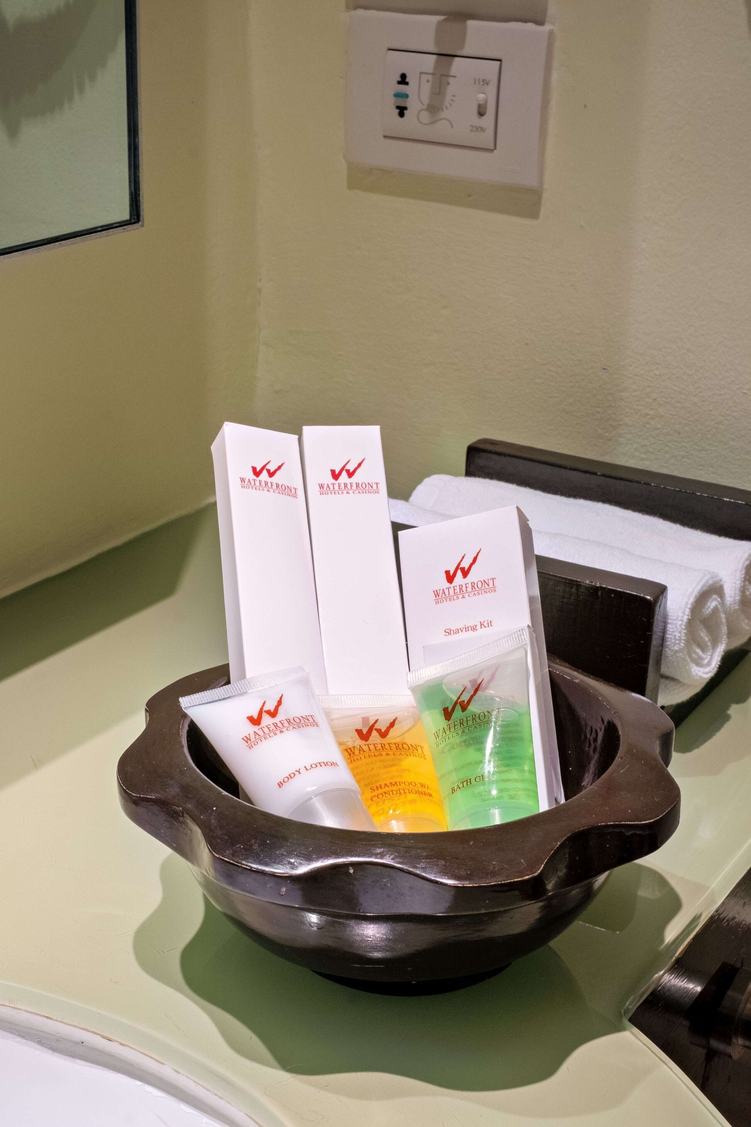 Ein Hotelbad mit Waschbecken, Spiegel und Pflegeprodukten in einer Schale.