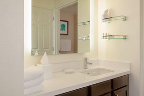 A modern bathroom with a white sink, a mirror, and glass shelves above the sink. - Residence Inn By Marriott Tampa Downtown (Tampa)