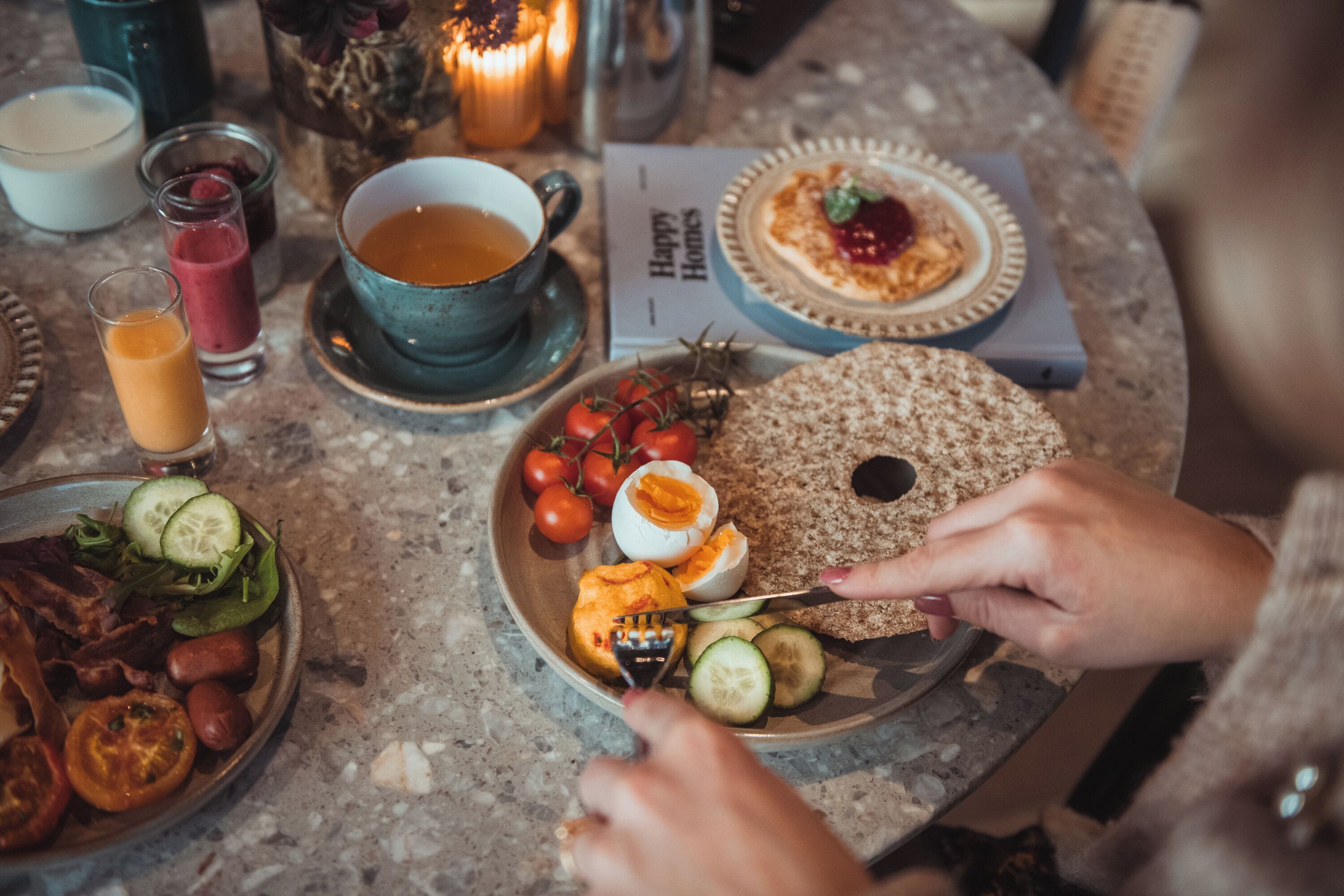 A breakfast setting with various food items and drinks on a table.