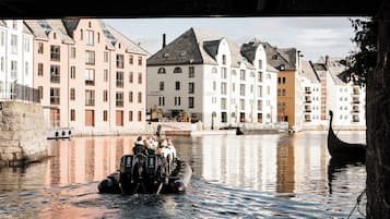 Ein Kanal mit einem Boot, das Passagiere befördert, umgeben von historischen Gebäuden unterschiedlicher Architektur.