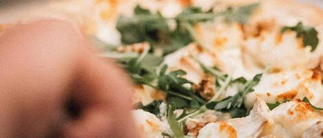 A pizza with greens on a plate.