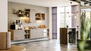A modern kitchen with built-in appliances, wooden cabinets, and a bar area with stools. - Mercure Hotel Stuttgart Gerlingen (Gerlingen)